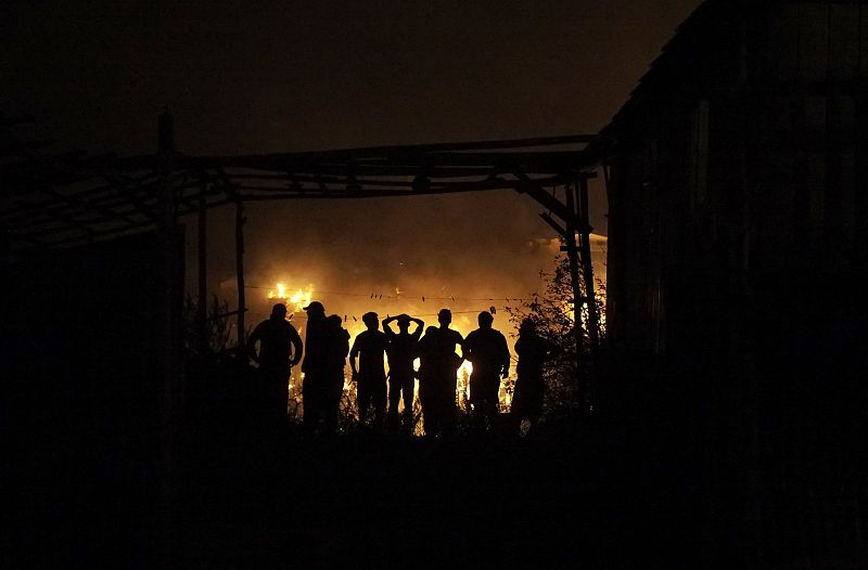 Un grupo de personas observa casas afectadas por el incendio en uno de los cerros de la ciudad de Valparaíso (Chile)