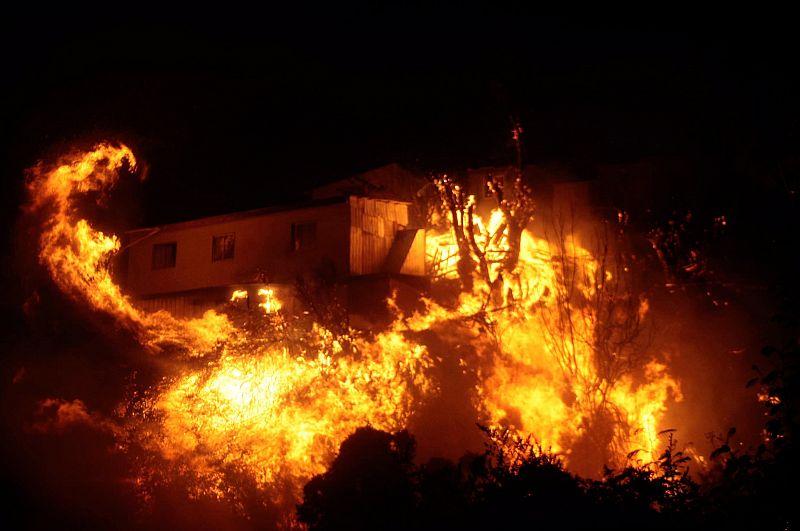 Un grupo de viviendas arde entre las llamas del incendio que ha arrasado centenares de hogares en Valparaíso, Chile