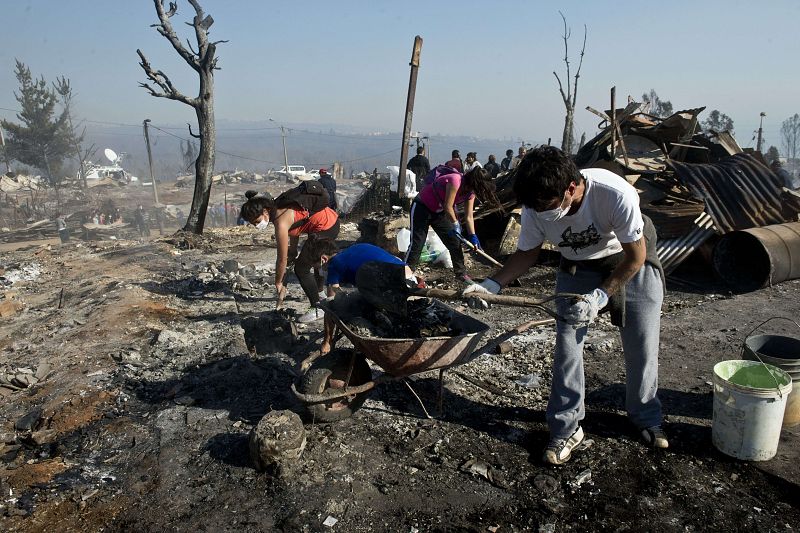 Los trabajos de extinción se mezclan con los esfuerzos de los vecinos por salvar sus pertenencias.