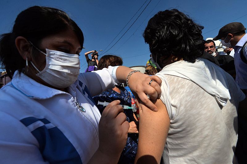 Voluntarios vacunan a los afectados contra el tétano días después de un incendio que aún no ha sido controlado en su totalidad.