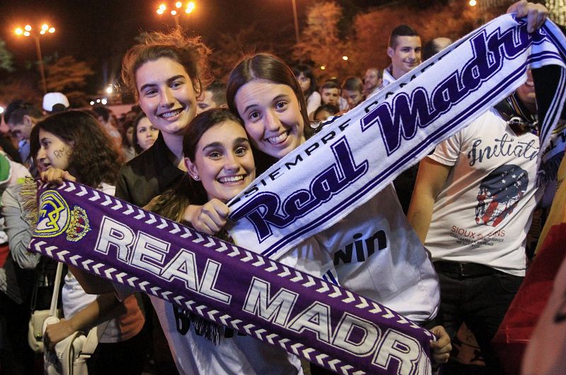 Un grupo de aficionadas muestra a cámara bufandas del equipo en la plaza de Cibeles.