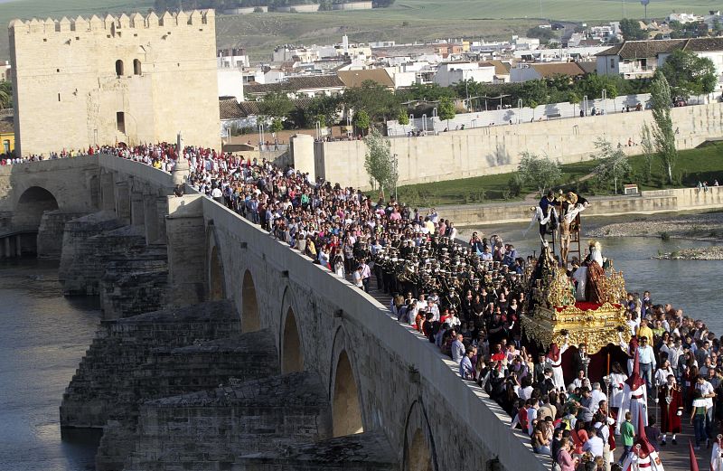 La hermandad del Descendimiento durante la procesión de Viernes Santo a su paso por el puente Romano de Córdoba.