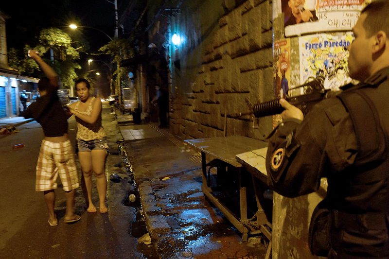 La policía apunta con sus armas a una pareja en una favela del turístico barrio de Copacabana.