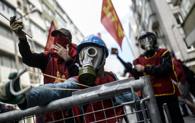 Manifestantes turcos con máscaras de gas y tirachinas se enfrentan a los agentes antidisturbios cerca de la plaza Taksim de Estambul.