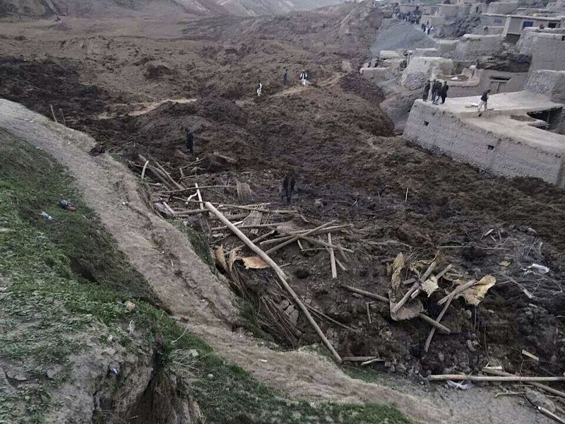 Afghan villagers gather at the site of a landslide at the Argo district in Badakhshan