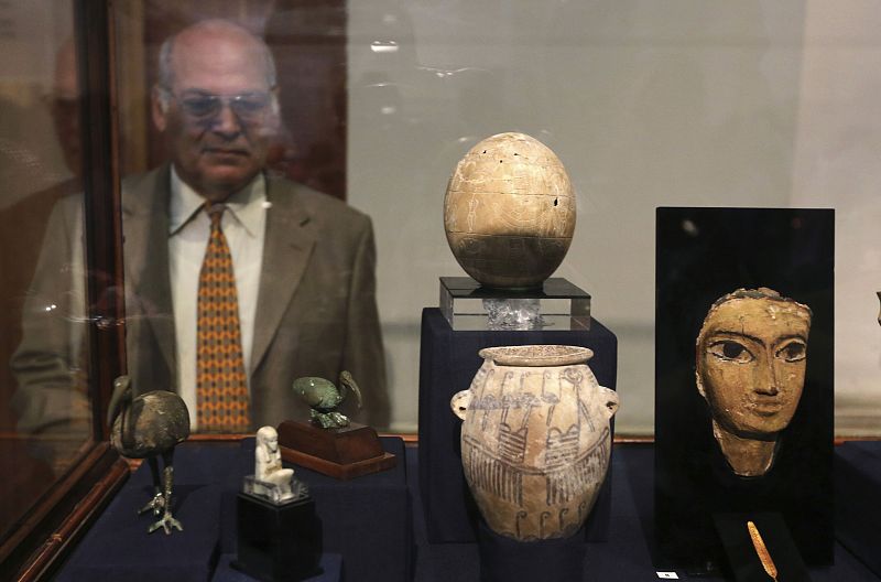 A man looks at artefacts on display during the inauguration of an exhibition of repatriated historical objects at the Egyptian Museum in Cairo