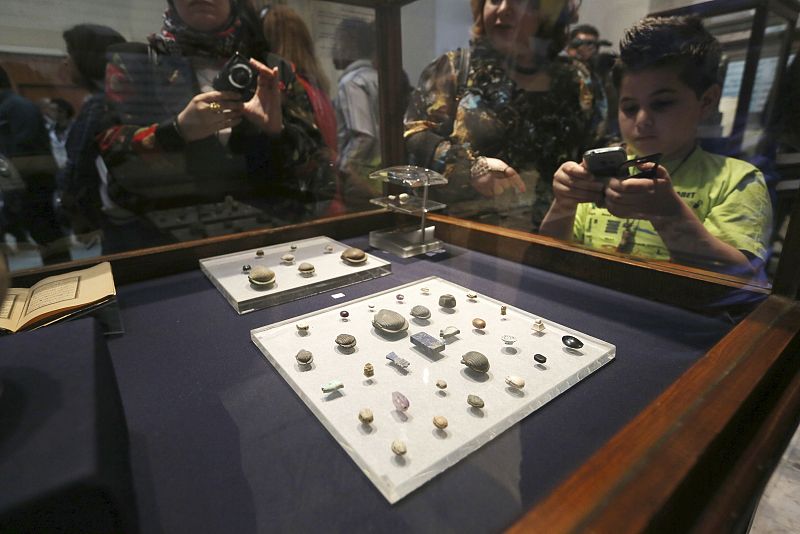 Visitors take pictures of artefacts on display during the inauguration of an exhibition of repatriated historical objects at the Egyptian Museum in Cairo