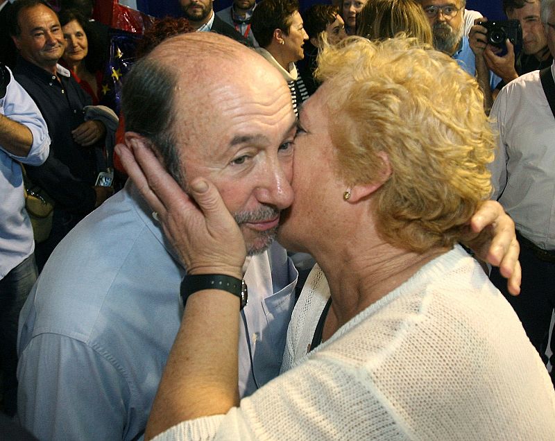 La imagen típica del político besando niños se torna aquí en una señora simpatizante de Rubalcaba que busca al candidato para besarlo.