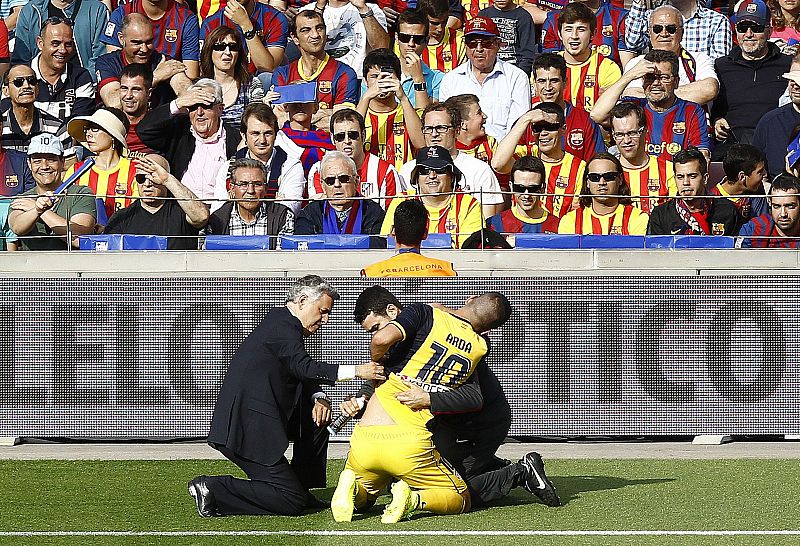 El jugador del Atlético de Madrid Arda Turan recibe atención médica