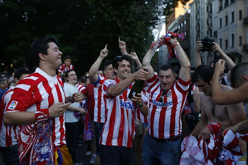 Aficionados colchoneros descorchan botellas en Neptuno para celebrar el título liguero conseguido por el Atletico Madrid en la última jornada ante el FC Barcelona