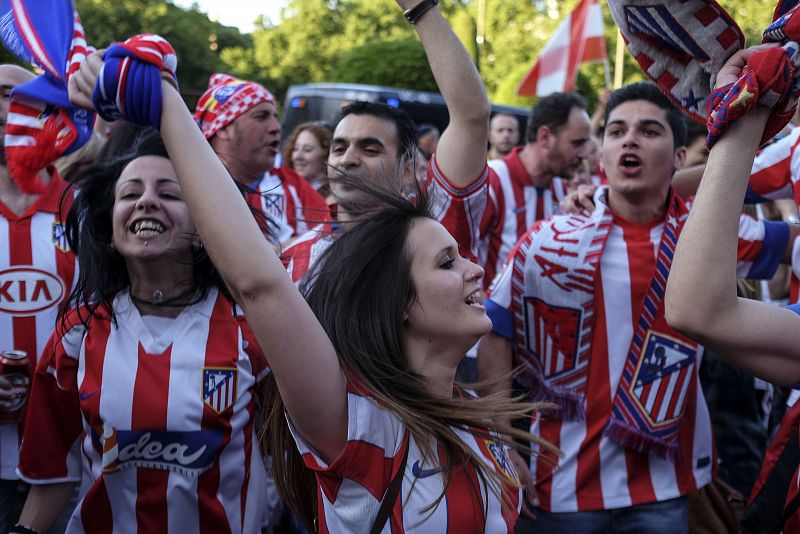 Aficionados colchoneros ondean bufandas y banderas durante la celebración del título liguero del Atletico de Madrid, en la fuente de Neptuno, en Madrid