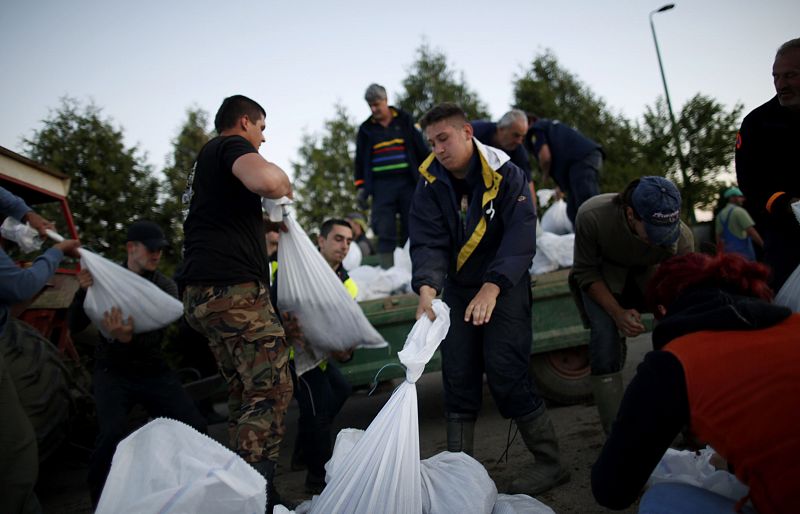 Un grupo de personas hacen barricadas para contener la crecida el rio Bosna