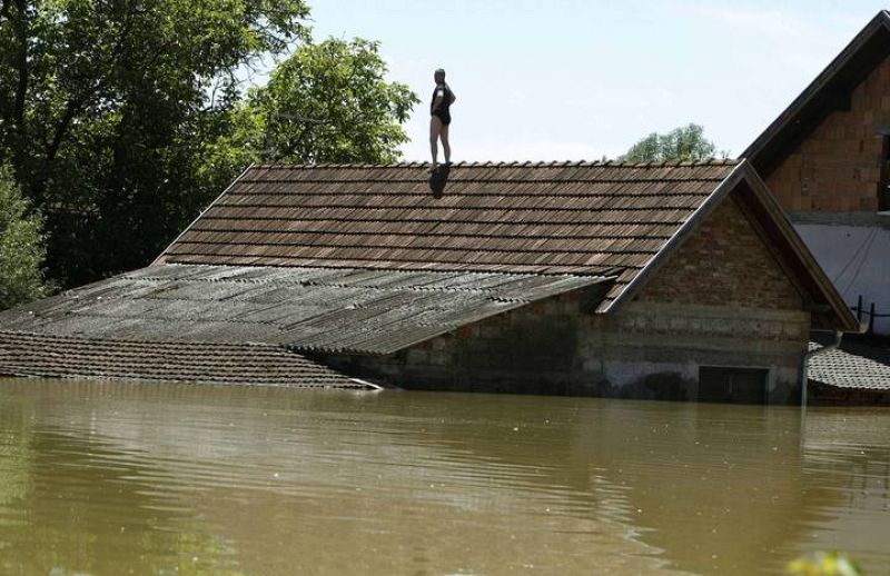 A man waits to be rescued from his house during heavy floods in Vojskova