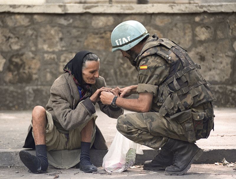 Un legionario español de la agrupación Canarias intenta convencer a una anciana para que evacue una zona de máximo peligro en la ciudad bosnia de Mostar en 1993.