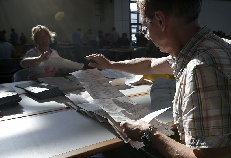 Electoral officials sort ballot papers after conclusion of voting in European Parliament elections in Munich