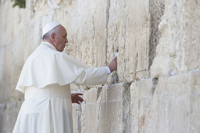 Pope Francis puts an envelope inside the stones of the Western Wall, Judaism's holiest prayer site, in Jerusalem's Old City