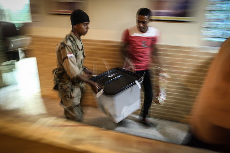 Egipcios acarreando una urna llena de votos en El Cairo