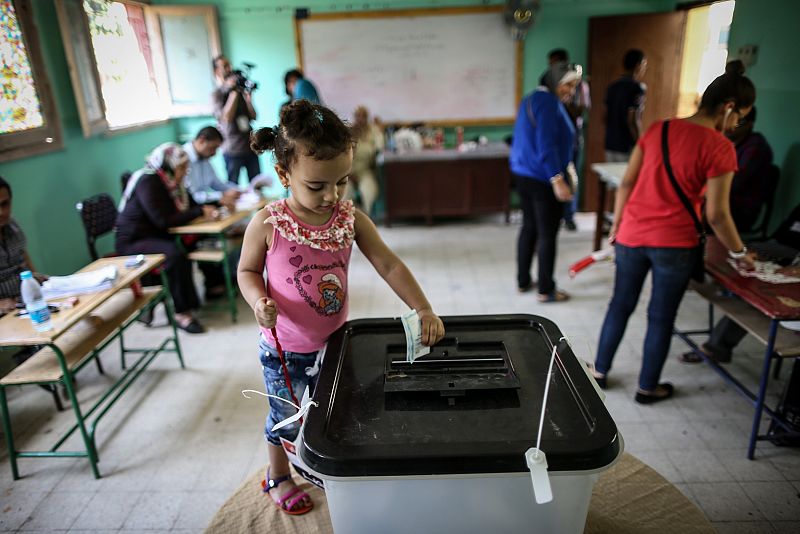 Un niño juega con una urna en un colegio electoral en El Cairo