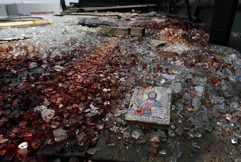 A bloodstained icon of Jesus is seen among blood soaked shattered glass atop a wrecked truck near the Donetsk airport