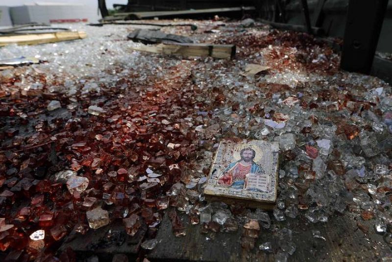 A bloodstained icon of Jesus is seen among blood soaked shattered glass atop a wrecked truck near the Donetsk airport