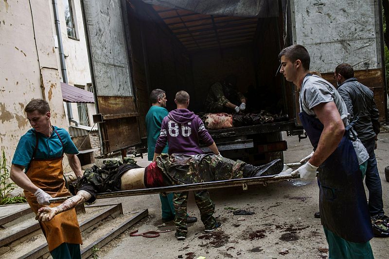 Trabajadores médicos y activistas prorusos descargan los cuerpos de combatientes de un camión en la ciudad ucraniana oriental de Donetsk