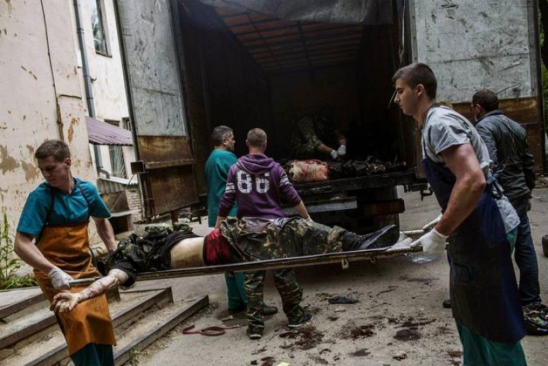 Trabajadores médicos y activistas prorusos descargan los cuerpos de combatientes de un camión en la ciudad ucraniana oriental de Donetsk