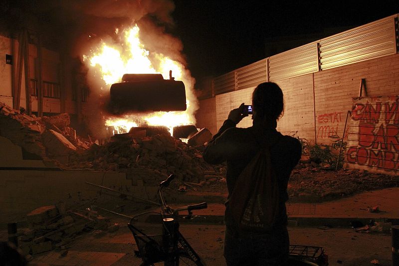 Una máquina excavadora en llamas frente a Can Vies