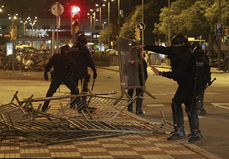 Los Mossos d'Esquadra retiran unas vallas que los manifestantes han colocado como barricadas durante los incidentes