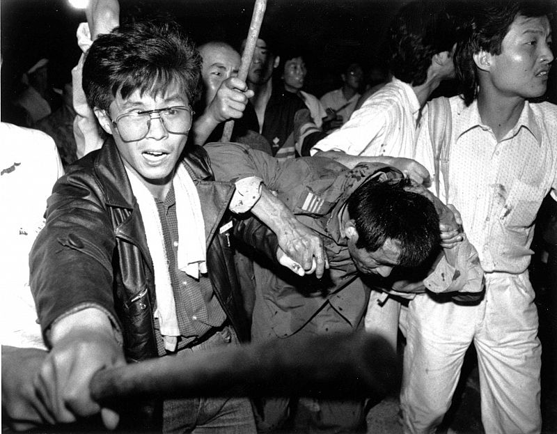 File photo of a captured tank driver being helped to safety by students as the crowd beats him in Beijing