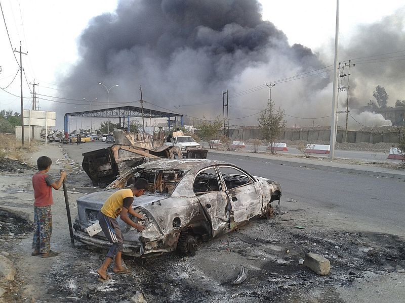 Niños junto a vehículo en Mosul. La ciudad es escenario de combates y la población civil está huyendo