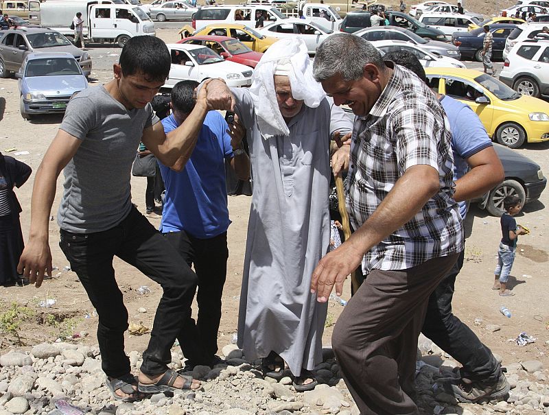 Un anciano es ayudado en el puesto de control de Arbil, donde están llegando miles de refugiados de Mosul