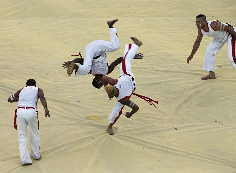 Artistas de la ceremonia bailan capoeira durante el espectáculo.