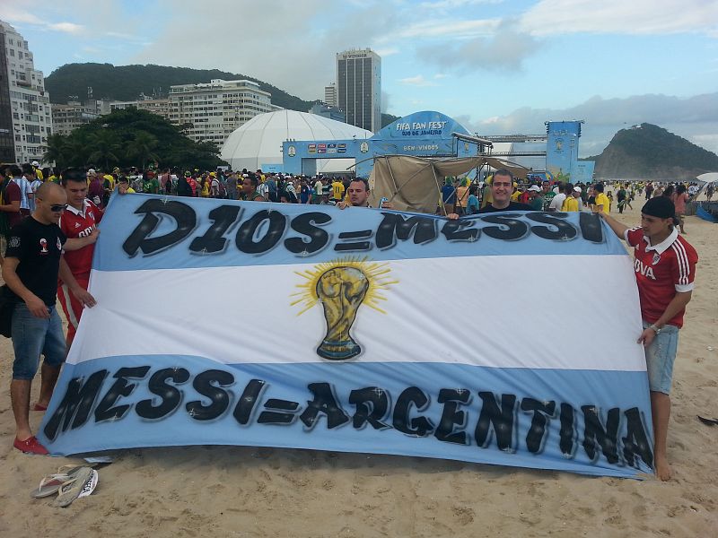 Un grupo de aficionados argentinos muestra su bandera en la playa de Copacabana.