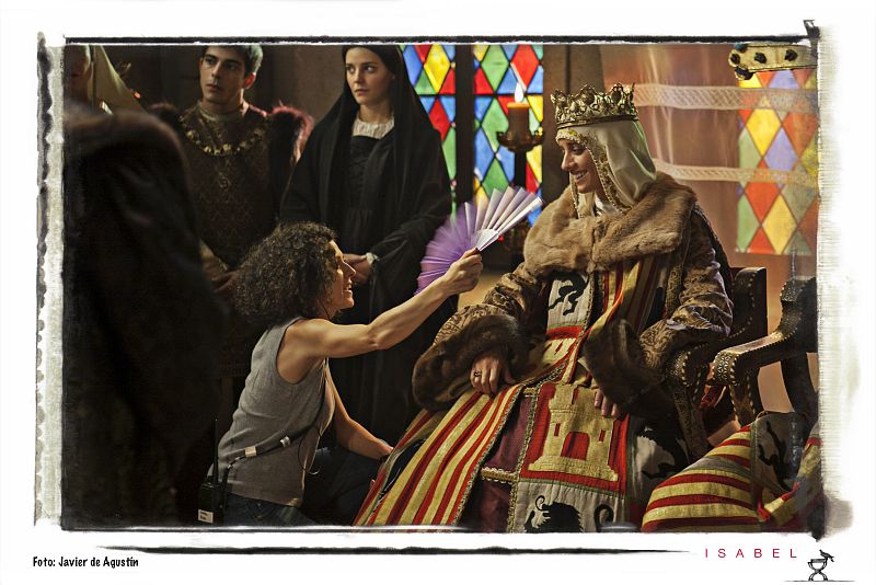 Llevar el traje de reina de Castilla es un poco complicado. Demasiadas capas y demasiada tela...¡Michelle Jenner pasa tanto calor que hay que abanicarla!