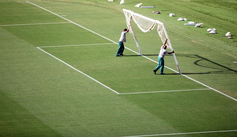 Unos operarios colocan las porterías del estadio.