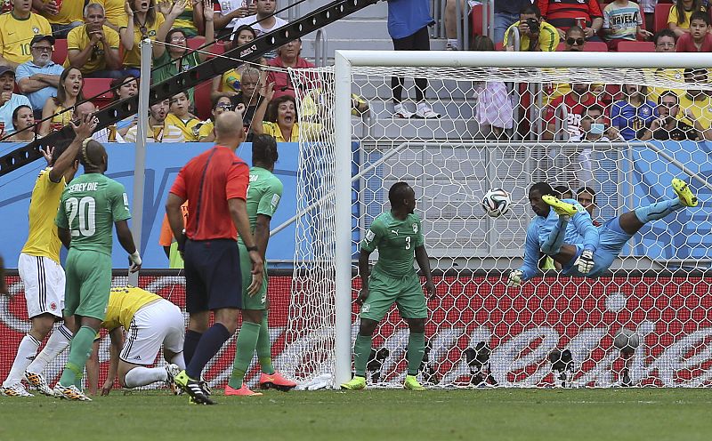 El balón lanzado por el centrocampista colombiano James Rodríguez (c) entra en la portería de Costa de Marfil