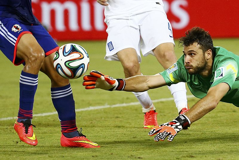 El portero griego Orestis Karnezis realiza una estirada para tratar de interceptar el balón contra la selección de Japón