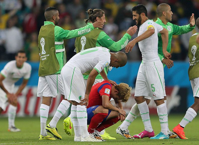 Sofiane Feghouli consuela al coreano Son Heungmin después de finalizar el encuentro.