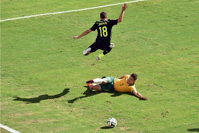 El jugador catalán Jordi Alba salta por encima del australiano Mathew Leckie.