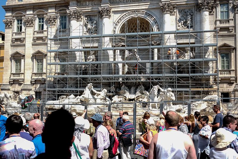 Turistas contemplan la Fontana de Trevi tras pantallas de protección