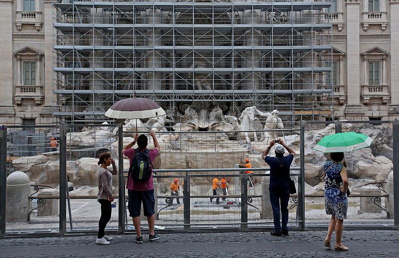 Turistas fotografiando la Fontana de Trevi en plena restauración