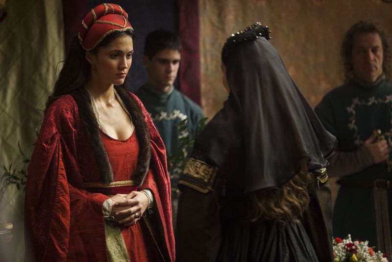 Se acerca a la dama que compite con ella en el lecho de su marido y le invita a su alcoba para agasajarla con unos bonitos encajes