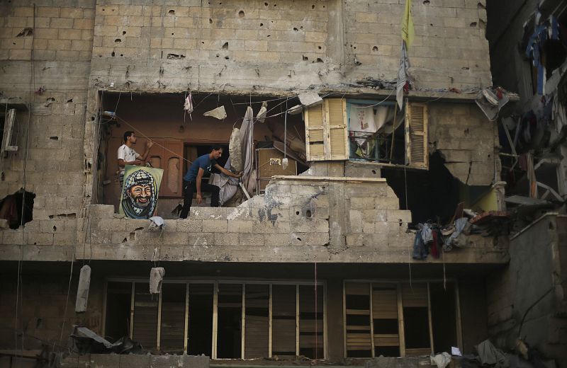 Palestinians inspect a house which police said was damaged in an Israeli air strike in Gaza City