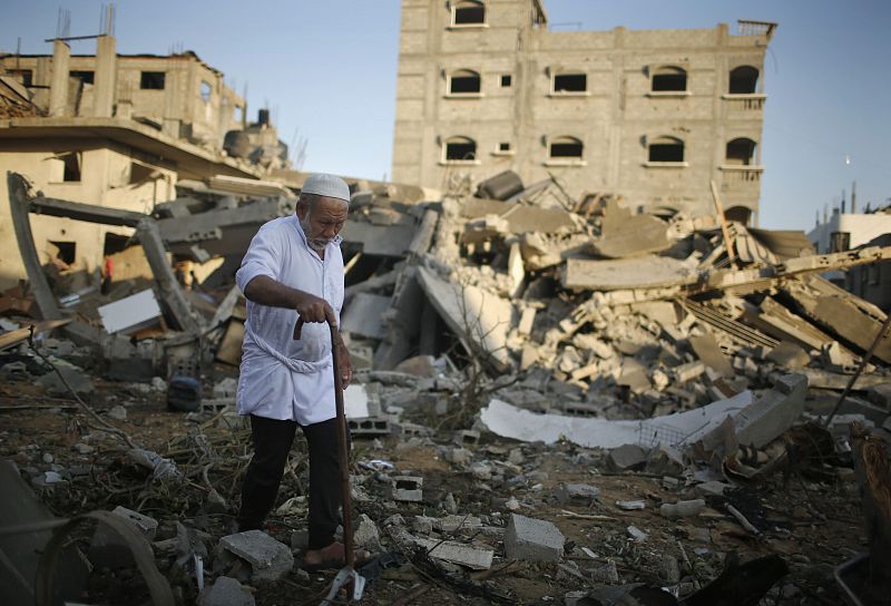 Un hombre palestino camina a través de los escombros de una casa destruida en un ataque aéreo