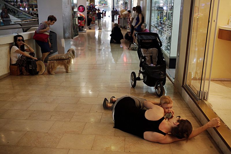 Una mujer espera tumbada con su bebé en el suelo de un centro comercial de Tel Aviv mientras suenan las alarmas antiaéreas que avisan de la llegada de cohetes