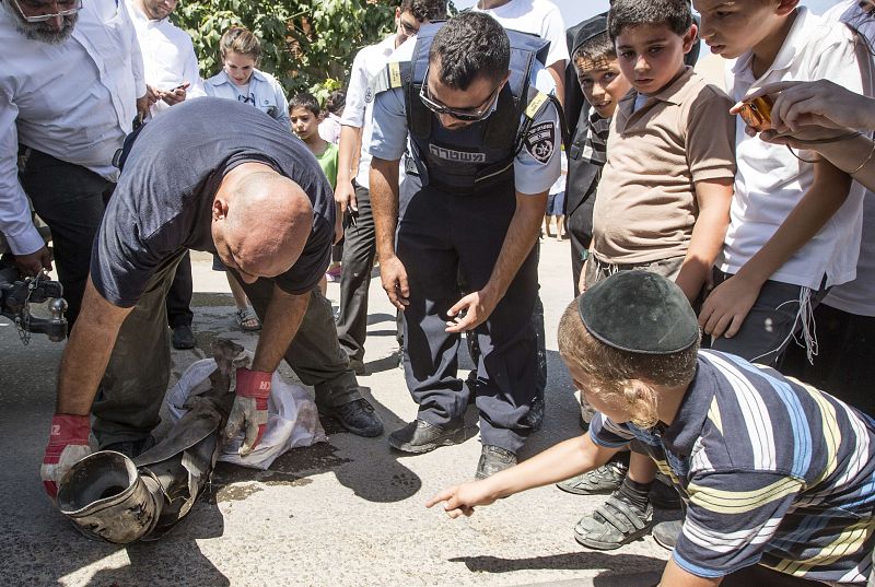 Expertos israelíes en desactivación de bombas recogen los restos de un cochete disparado por militantes palestinos desde la Franja de Gaza