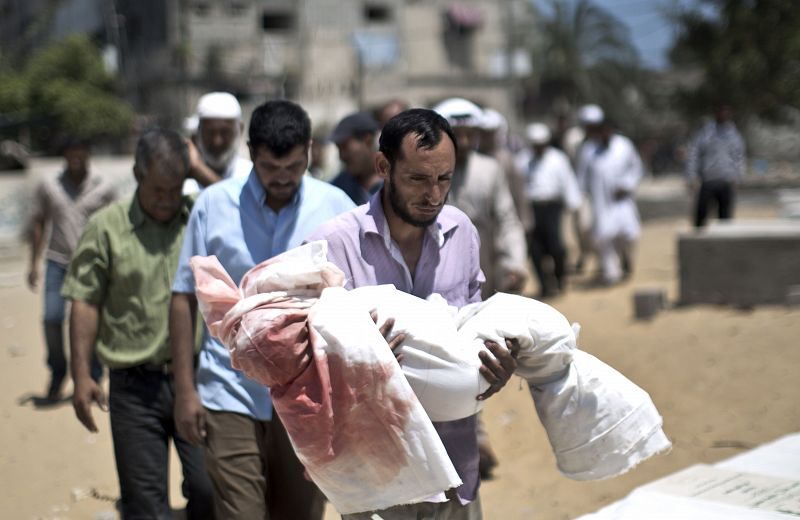 Un hombre palestino sostiene el cuerpo de un niño de cinco años durante su funeral en la ciudad de Beit Lahiya, en el norte de Gaza