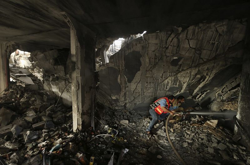 Un bombero palestino extingue las llamas en una casa bombardeada