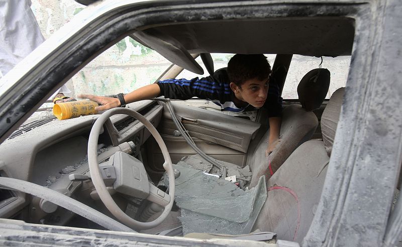 Un joven palestino inspecciona un coche dañado por los bombardeos israelíes en Rafah, al sur de la Franja de Gaza