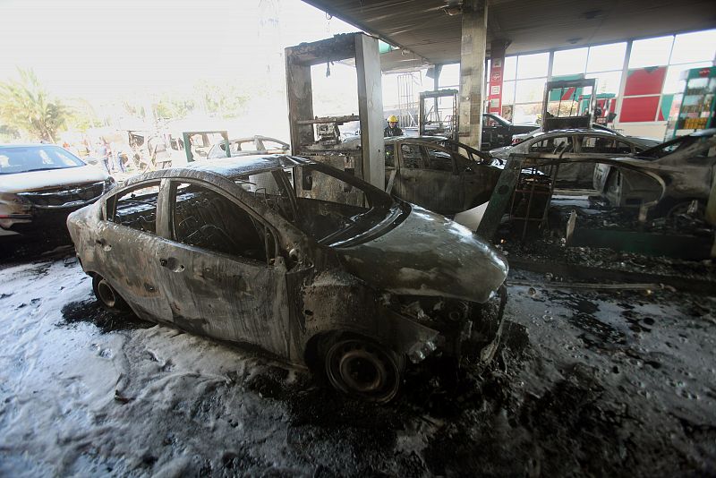 Coches destruidos por el impacto de un cohete en una gasolinera al sur de Israel